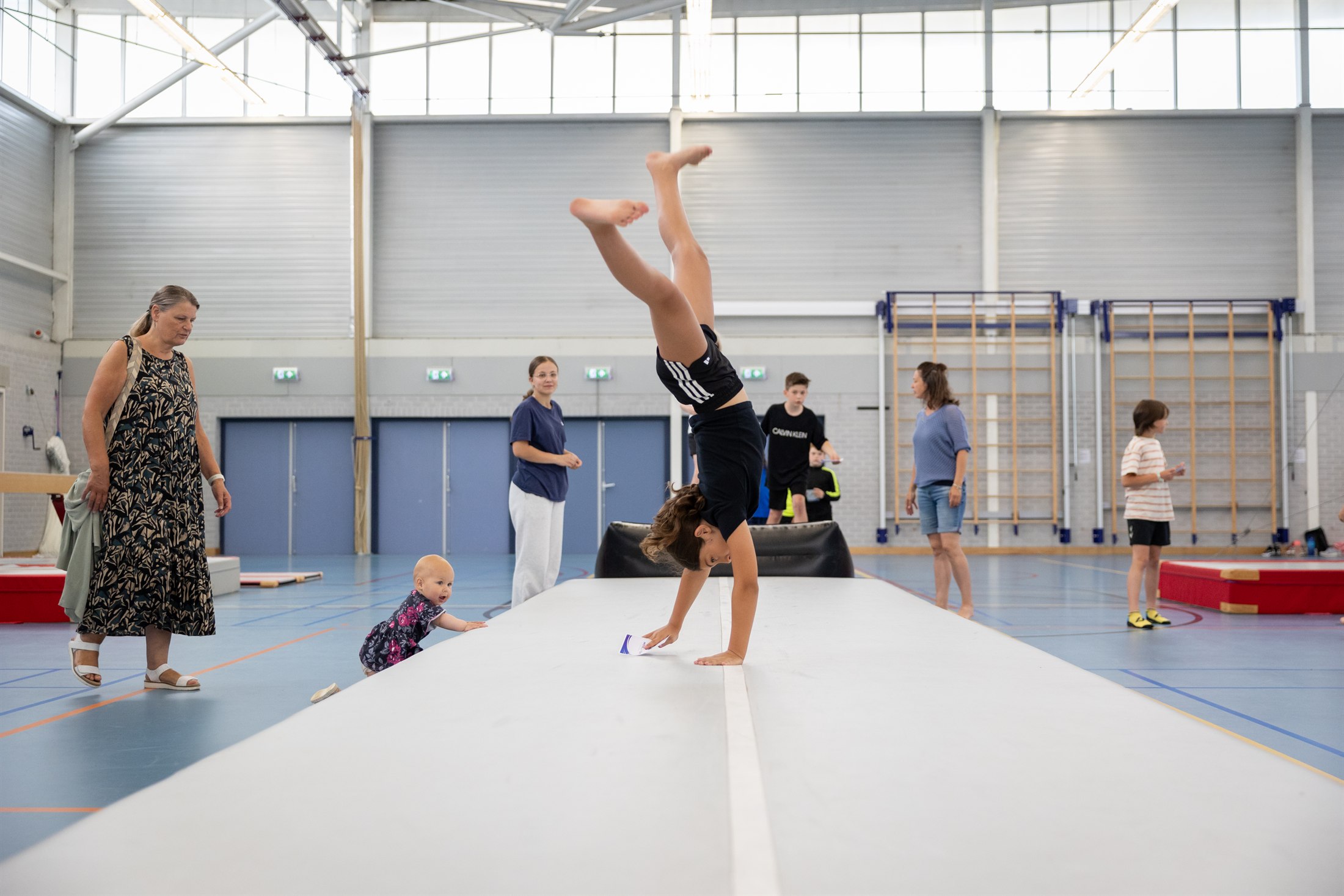 Turnster oefent een handstand op de airtrack